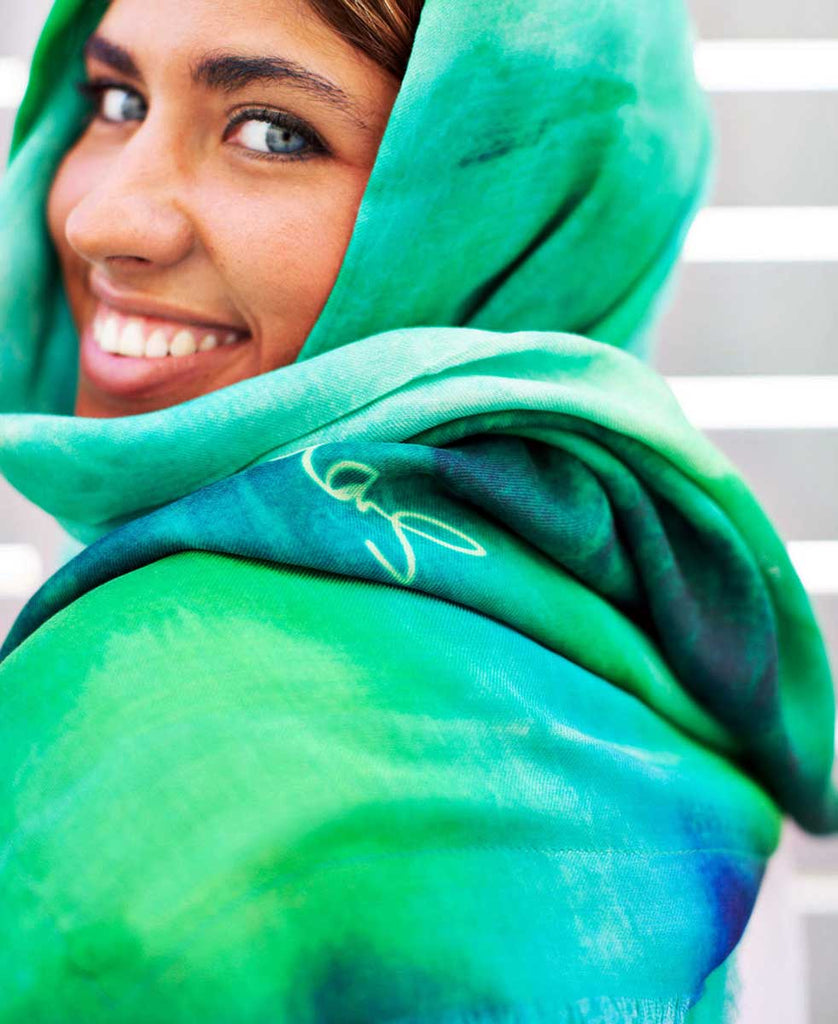 smiling green eyes girl wearing printed green and blue scarf with original art design and artist signature