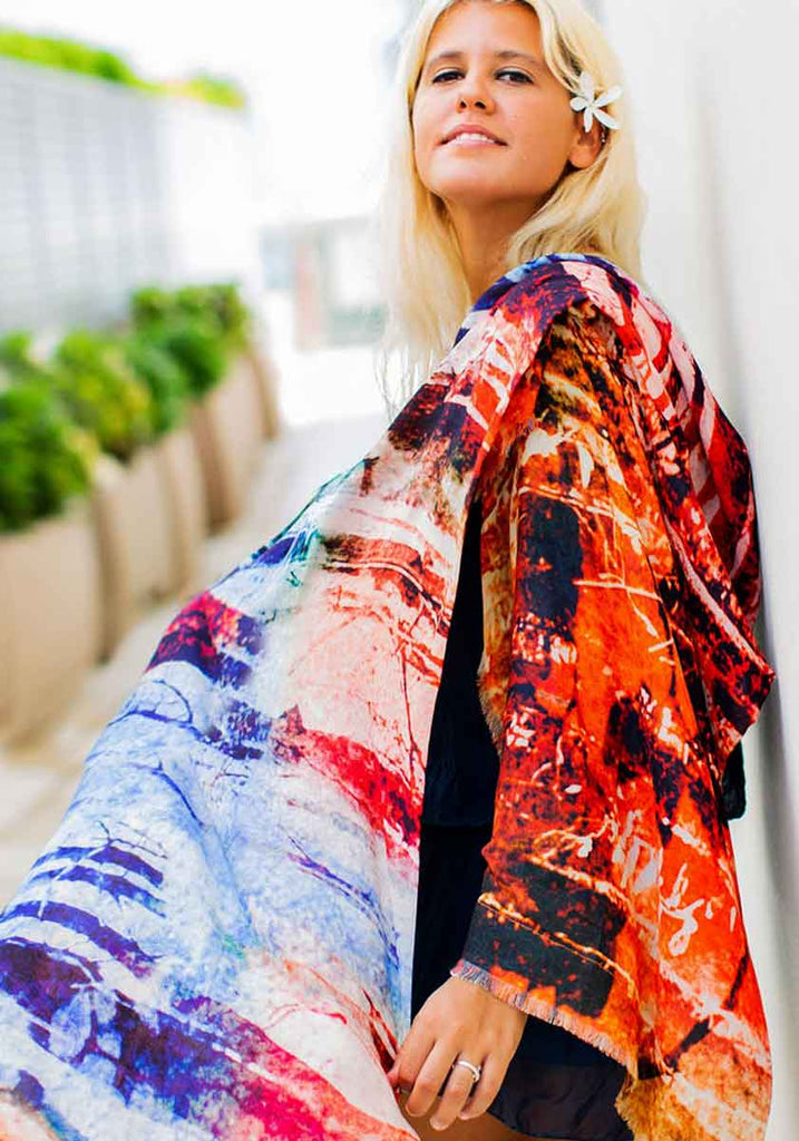 Young blonde woman wearing multi-coloured scarf with original art design