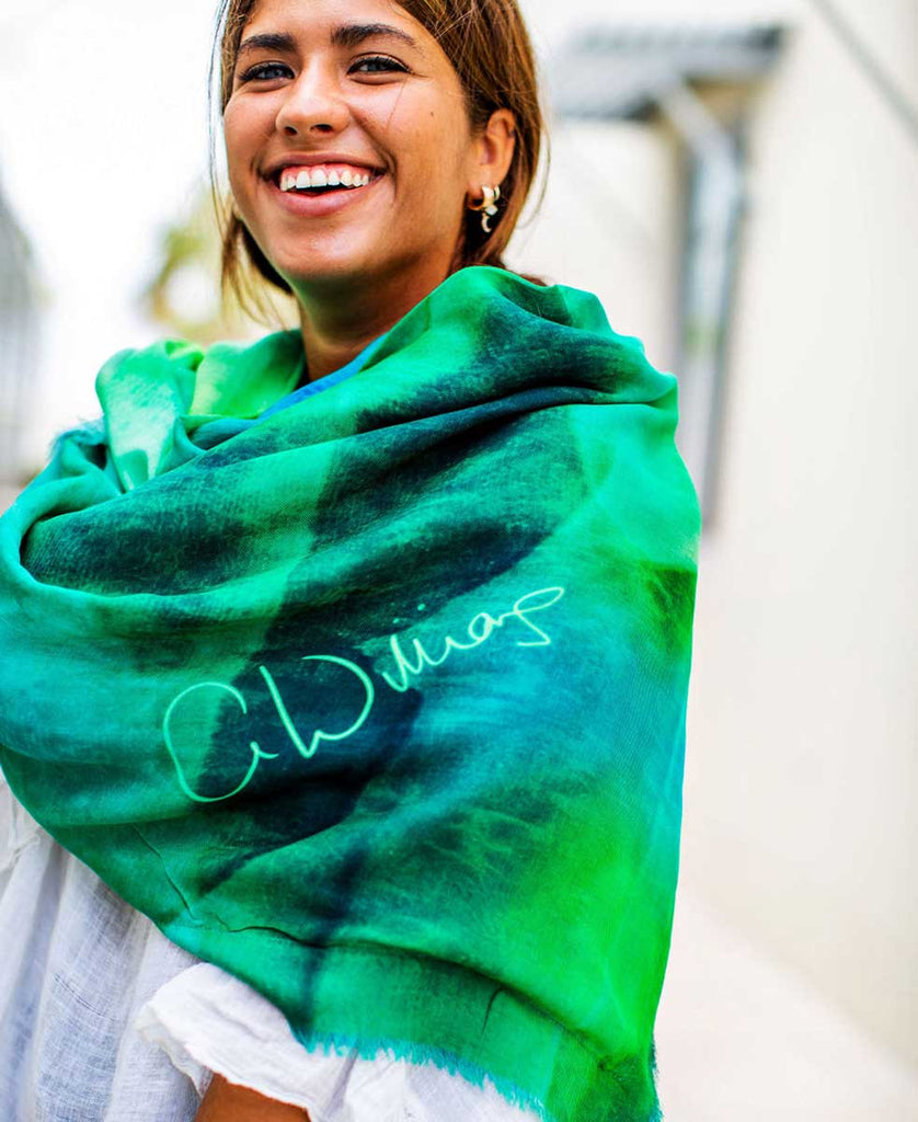 smiling girl wearing printed green and blue scarf with original art design and artist signature